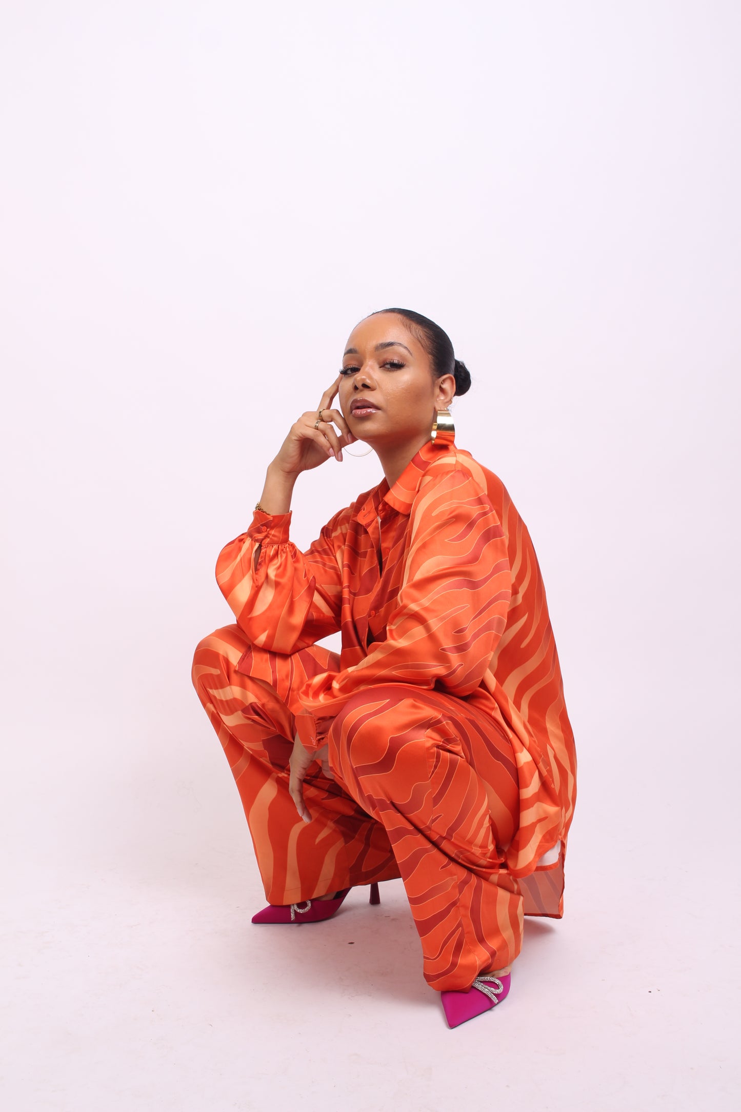 orange oversized shirt and wide leg trousers with pink heels